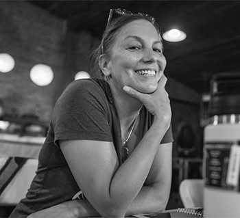 black and white of Simone Senogles resting shin on hand and smiling