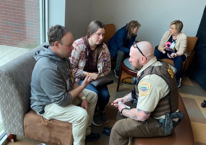 Bemidji police officer Zach Rupert interviews Beltrami County Health and Human Services staff who are role playing as emergency shelter guests, as part of a shelter training in April 2025.
