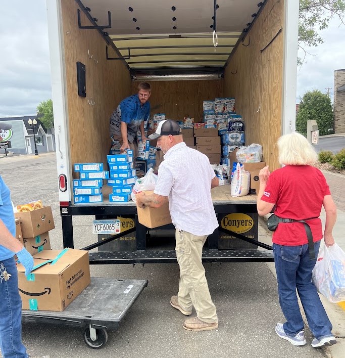 Volunteers move supplies donated from local stores to a tent outside the Beltrami County office.