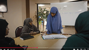 four Somali women talk around a table