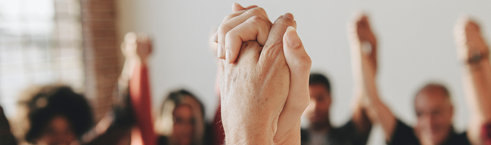 group meeting with people holding hands
