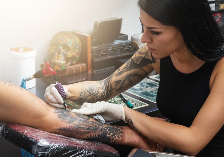 body artist tattooing an arm